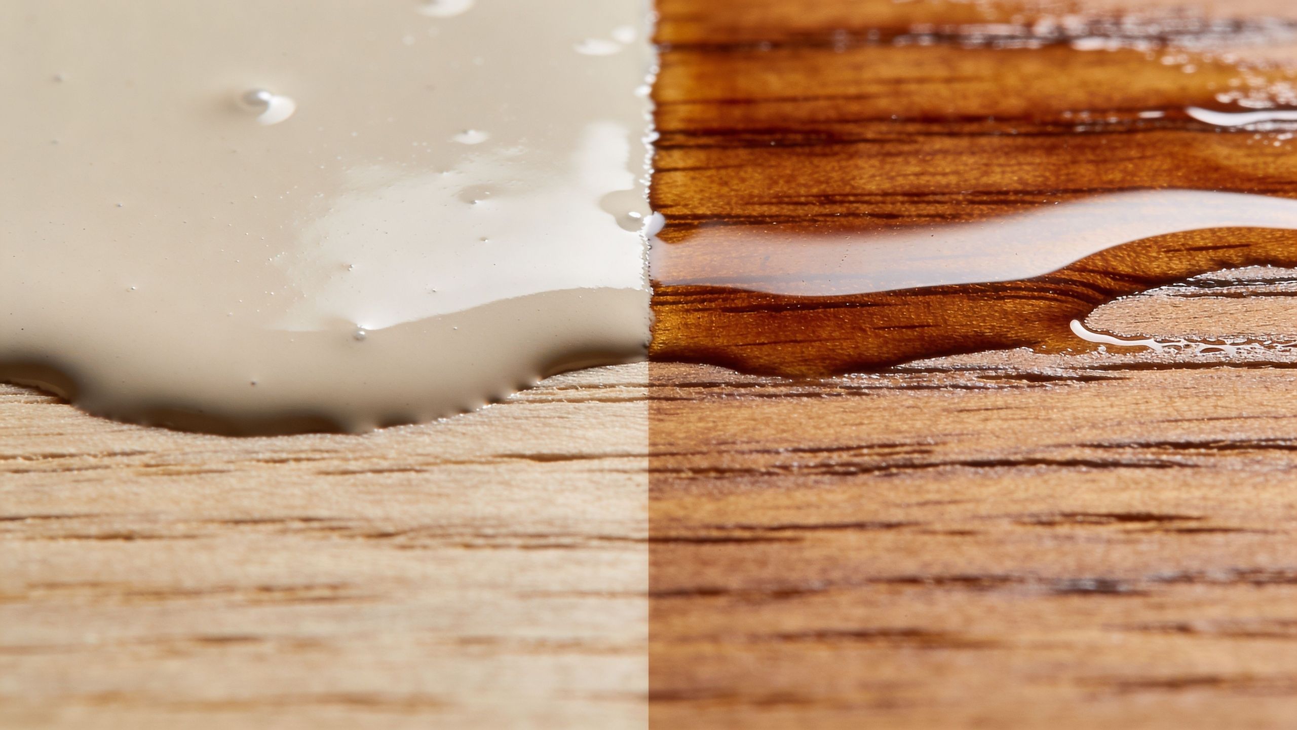 A close-up view comparing paint on raw wood versus wood stain on finished wooden flooring material.